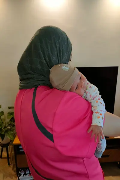 Hanan El Morabit, kraamverzorgende bij 'T Gouden Hartje, wiegt liefdevol een pasgeboren baby