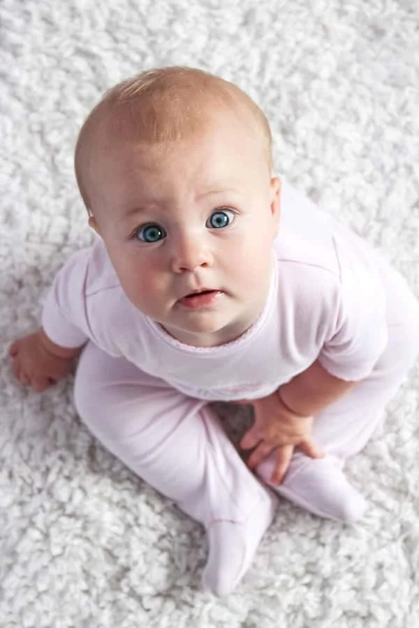 Pasgeboren baby met blauwe ogen in een zachte doek, kraamzorg in Almere